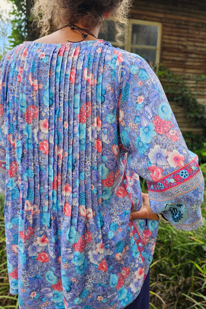 Woman wearing a colorful floral 3/4 sleeve top