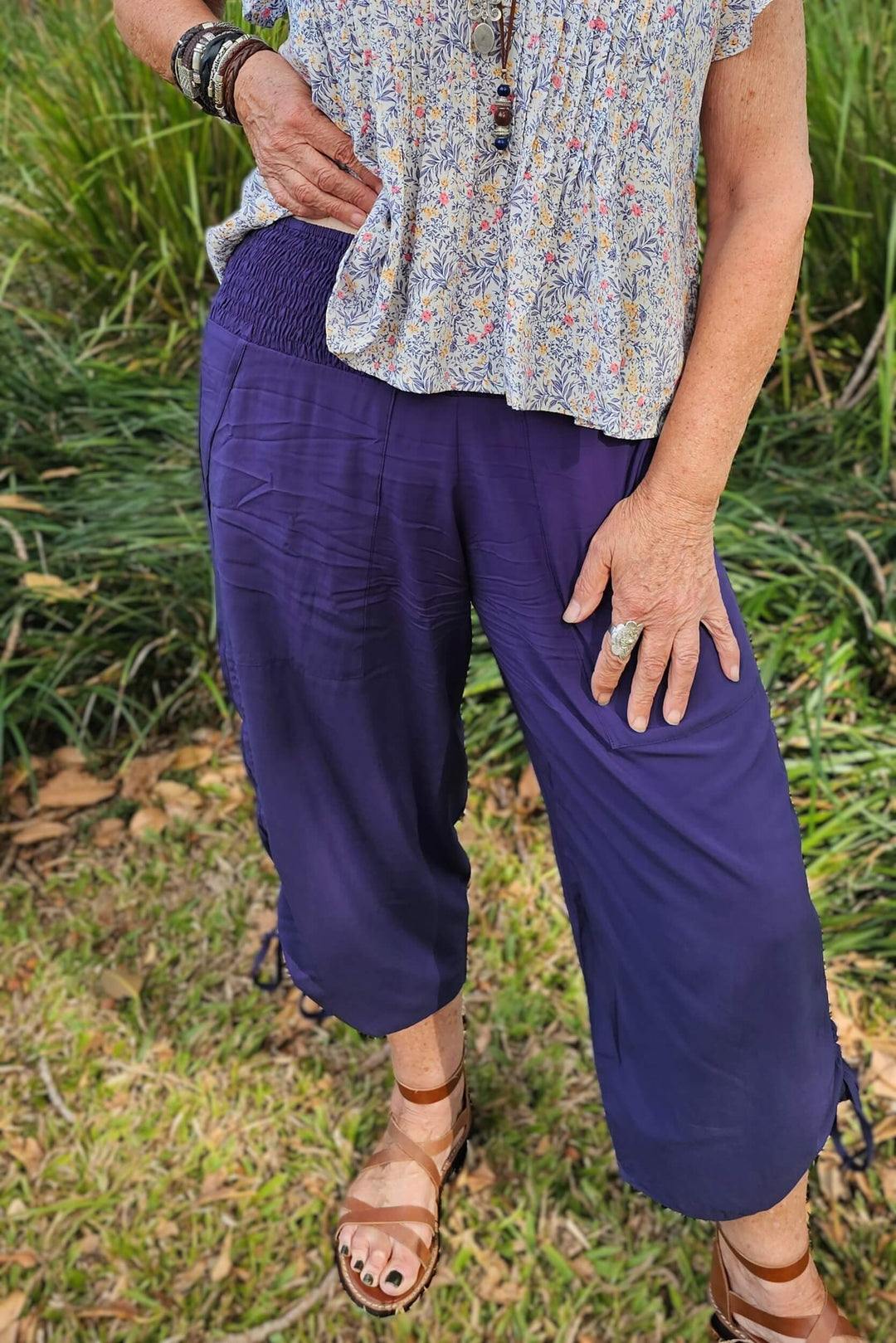 Person wearing navy pants with an elasticated waistband and pockets.