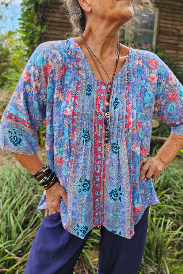 Woman wearing a lavender floral blouse on a summer day