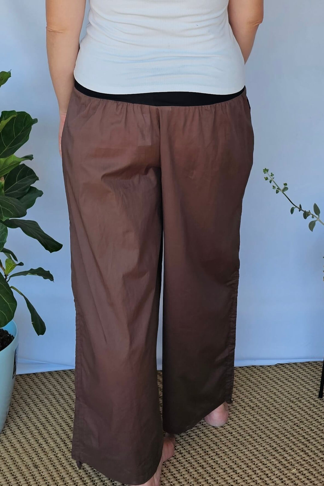 Back view of high-waisted coffee coloured pants in cotton fabric
