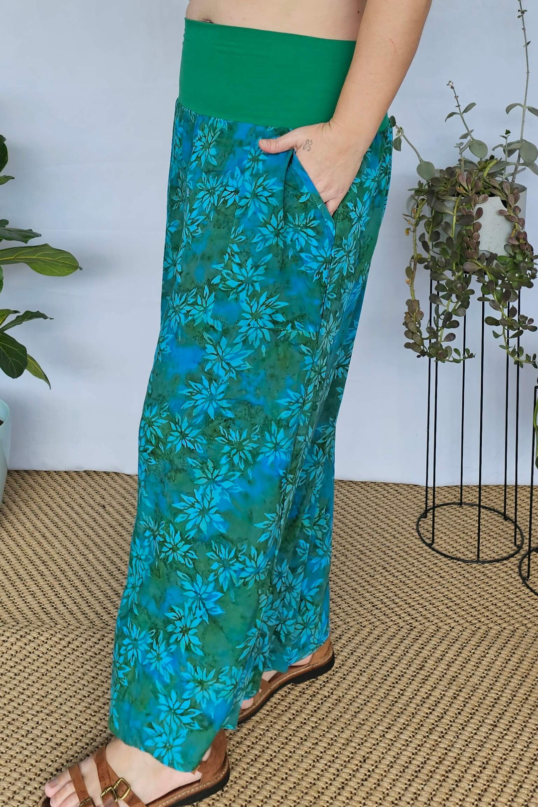 Model with hand in deep pocket of teal palazzo pants