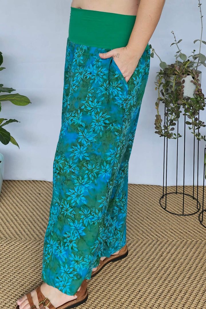 Model with hand in deep pocket of teal palazzo pants