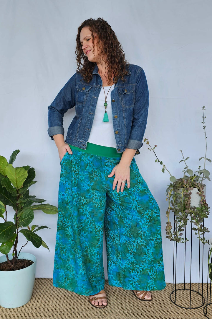 Teal palazzo pants styled with a white tank and denim jacket