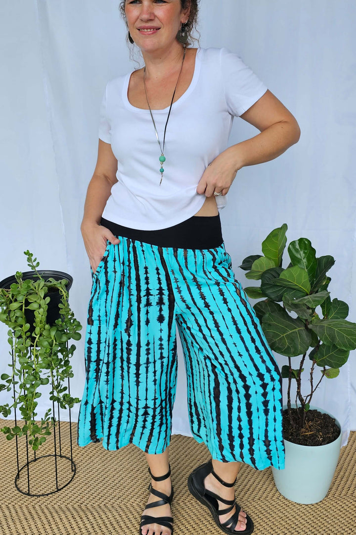 Model wearing Sea Breeze 7/8 Palazzo Pants with aqua tiedye, wide-leg silhouette, and comfortable stretch waistband.