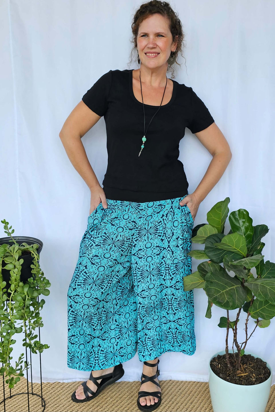 Model styling Blue Mandala Palazzo Pants with a casual top, showing the flattering 7/8 length and comfortable waistband.