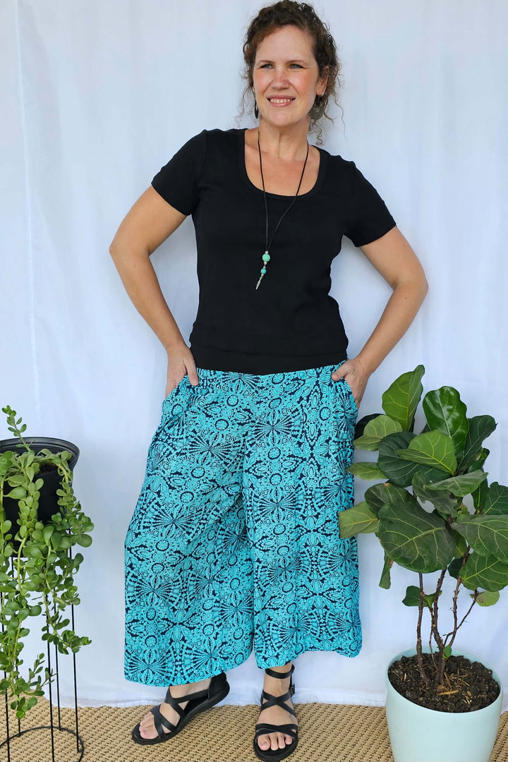 Model styling Blue Mandala Palazzo Pants with a casual top, showing the flattering 7/8 length and comfortable waistband.