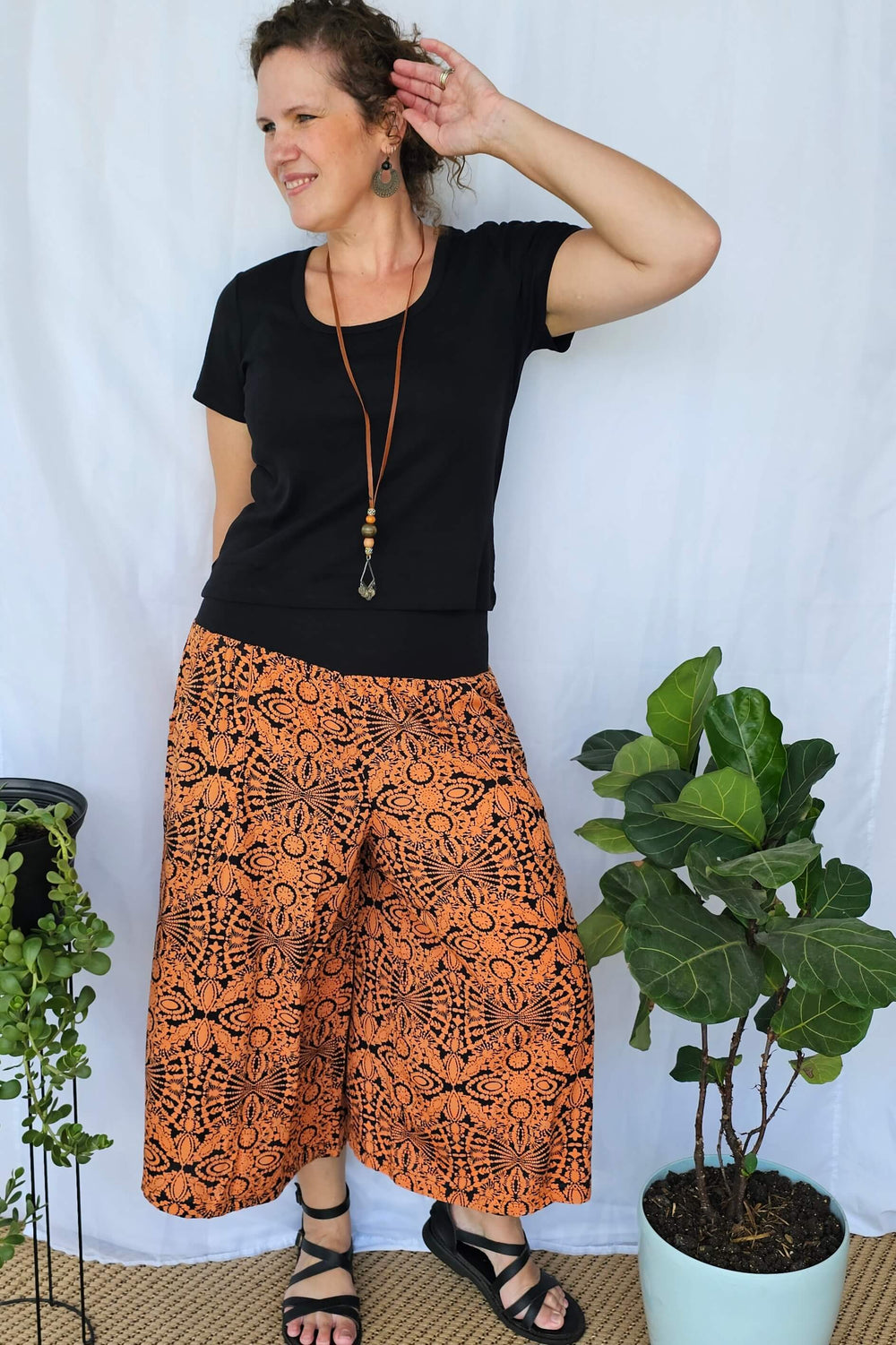 Model wearing Orange Mandala 7/8 Palazzo Pants with wide leg fit and soft stretch waistband, showing the vibrant mandala print and relaxed silhouette.