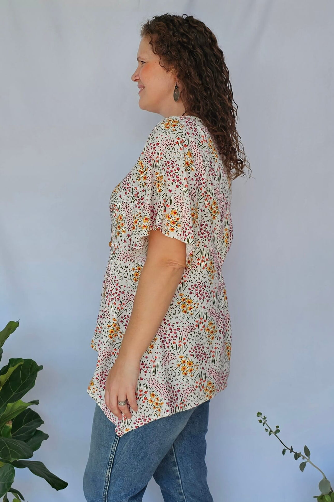Side view of floral rayon top with dipped hem in sizes 14–26